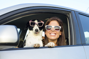 girl with dog in car both sunglasses